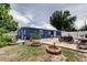 A house with a blue exterior featuring an open backyard and concrete patio area, along with a motorcycle at 4727 Town N Country Blvd, Tampa, FL 33615