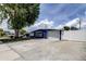 Blue single-story home with a white garage door, fence, and a well-maintained driveway at 4727 Town N Country Blvd, Tampa, FL 33615