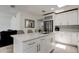 Bright kitchen featuring a center island, stainless steel appliances, white cabinets, and modern finishes at 4727 Town N Country Blvd, Tampa, FL 33615
