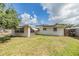 Partially grassy backyard featuring a covered patio area and mature trees that offer a touch of nature at 5414 Oceanic Rd, Holiday, FL 34690