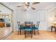 Dining area with hardwood floors, seating for four, ceiling fan, and sliding door to adjacent living room at 5414 Oceanic Rd, Holiday, FL 34690