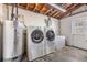 Functional laundry room with a modern washer and dryer set, efficient water heater, and ample storage at 5414 Oceanic Rd, Holiday, FL 34690