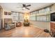 Bright living room featuring hardwood floors, ceiling fan, and large windows at 5414 Oceanic Rd, Holiday, FL 34690