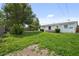 A spacious backyard featuring healthy green grass and some trees with some partially fenced perimeter at 5627 57Th N Ave, St Petersburg, FL 33709
