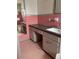 Retro bathroom featuring pink tiling, vanity with sink, and a large mirror at 5631 23Rd S Ave, Gulfport, FL 33707