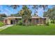 A single-story home featuring a screened-in porch and a lush green lawn with palm tree at 5631 23Rd S Ave, Gulfport, FL 33707