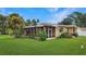 A yellow, single-story home with a screened-in porch and a spacious, well-manicured lawn at 5631 23Rd S Ave, Gulfport, FL 33707