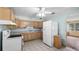A simple kitchen with light wood cabinets, white appliances, and tiled floors at 5631 23Rd S Ave, Gulfport, FL 33707
