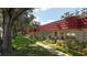 Charming condos with red roofs line a sidewalk through a well-maintained lawn and mature trees at 5870 38Th N Ave # 44, St Petersburg, FL 33710