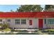 Neat exterior view of condo featuring vibrant red door and well-kept landscaping at 5870 38Th N Ave # 44, St Petersburg, FL 33710