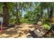 Large wooden deck with seating area is shaded by mature trees in the backyard at 6016 N Dexter Ave, Tampa, FL 33604
