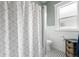 Updated bathroom features a shower with white geometric patterned curtain and tiled floors at 6016 N Dexter Ave, Tampa, FL 33604