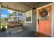 Inviting front porch featuring a porch swing, welcome mat, and a decorative wreath on the front door at 6016 N Dexter Ave, Tampa, FL 33604
