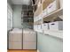 Functional laundry room equipped with washer, dryer, and built-in shelving for optimal storage at 6016 N Dexter Ave, Tampa, FL 33604
