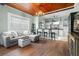 Open-concept living room featuring hardwood floors, wood ceilings, a fireplace, and access to kitchen at 6016 N Dexter Ave, Tampa, FL 33604