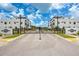 Gated community entrance with black iron gates, manicured landscaping, and modern white townhome buildings at 6210 64Th N Way, Pinellas Park, FL 33781