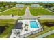 Aerial view of a community pool area featuring lounge chairs, a pool house, and well-maintained landscaping at 6210 64Th N Way, Pinellas Park, FL 33781
