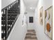 Elegant hallway with black railing, decorative wall art, modern lighting, and wood-look floors at 6210 64Th N Way, Pinellas Park, FL 33781