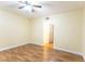 Cozy room featuring wood-look flooring, ceiling fan, and a door leading to another room at 6332 Newtown Cir # 32B2, Tampa, FL 33615
