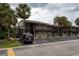 Exterior shot of a condo building with palm trees, parking, and a dark red SUV at 6332 Newtown Cir # 32B2, Tampa, FL 33615