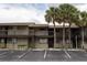 Two story condo building featuring palm trees, reserved parking and a welcoming facade at 6332 Newtown Cir # 32B2, Tampa, FL 33615