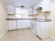 Bright kitchen featuring white cabinetry, tile floors, and modern appliances at 6332 Newtown Cir # 32B2, Tampa, FL 33615
