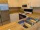 Bright kitchen with a stainless steel refrigerator, stove, microwave, and double basin sink at 642 Bird Bay E Dr # 205, Venice, FL 34285