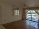 Living room with laminate flooring, a ceiling fan and sliding doors leading to a balcony at 642 Bird Bay E Dr # 205, Venice, FL 34285