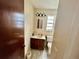 Bathroom features a single sink vanity and toilet with wood-look vinyl flooring at 6781 121St Ave # H, Largo, FL 33773
