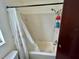 Bright bathroom featuring a shower/tub with white tile and curtain at 6781 121St Ave # H, Largo, FL 33773
