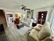Spacious living room with wood-look flooring and a mix of comfortable seating options at 6781 121St Ave # H, Largo, FL 33773