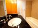 Bathroom featuring updated granite countertop, tub and tiled walls at 720 Lyndhurst St # 1104, Dunedin, FL 34698
