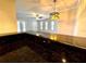 View of living area from kitchen featuring dark granite countertops and updated lighting at 720 Lyndhurst St # 1104, Dunedin, FL 34698