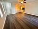Spacious living room with modern wood flooring, fan and an open view to kitchen at 720 Lyndhurst St # 1104, Dunedin, FL 34698