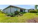 Well-maintained backyard showcasing a lush lawn, landscaping, and the home's exterior at 7683 Summerland Cv, Lakewood Ranch, FL 34202