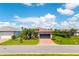 Single-story home with tile roof, brick driveway, lush landscaping, and well-maintained lawn at 7683 Summerland Cv, Lakewood Ranch, FL 34202