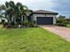 Charming single-story home featuring a brick driveway, tile roof, and lush tropical landscaping at 7683 Summerland Cv, Lakewood Ranch, FL 34202