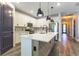Stylish kitchen featuring a large island, pendant lights, stainless steel appliances, and wood accents at 7683 Summerland Cv, Lakewood Ranch, FL 34202