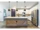 Modern kitchen with quartz countertops, pendant lighting, stainless steel appliances, and wood flooring at 7683 Summerland Cv, Lakewood Ranch, FL 34202