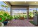 Relaxing screened lanai featuring serene lake views and lush tropical landscaping at 7683 Summerland Cv, Lakewood Ranch, FL 34202
