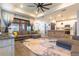 Open living space with a large sectional sofa, modern ceiling fan, and seamless flow to the kitchen at 7683 Summerland Cv, Lakewood Ranch, FL 34202
