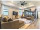 Spacious living room featuring tray ceilings, large windows, and a stylish sectional sofa at 7683 Summerland Cv, Lakewood Ranch, FL 34202