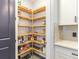 Well-organized walk-in pantry featuring wood shelving for optimal storage in this modern kitchen at 7683 Summerland Cv, Lakewood Ranch, FL 34202