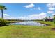 Scenic community pond surrounded by well-manicured lawns and mature palm trees at 7683 Summerland Cv, Lakewood Ranch, FL 34202