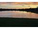 Tranquil sunset view over the community pond, reflecting a colorful sky at 7683 Summerland Cv, Lakewood Ranch, FL 34202
