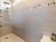 Walk-in shower features sleek tile work with decorative accents and a modern shower head at 7683 Summerland Cv, Lakewood Ranch, FL 34202