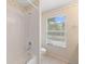 Clean white bathroom with a shower-tub combo, window and toilet at 8222 Haven Harbour Way, Bradenton, FL 34212