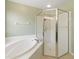 Bright bathroom featuring a soaking tub, glass-enclosed shower, and neutral tile flooring at 8222 Haven Harbour Way, Bradenton, FL 34212
