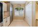 Bright kitchen area with white cabinets, a stainless steel fridge, a pantry, and a view of the landscaped yard at 8222 Haven Harbour Way, Bradenton, FL 34212