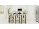 Bright kitchen featuring white cabinetry, stainless steel appliances, and stylish island seating for casual dining at 8544 Bella Mar Trl, Parrish, FL 34219